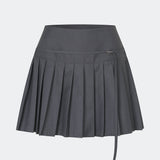 Plisseret mininederdel med et moderne og preppy udtryk. Cirkelinemd skirt har en lav talje med et wrap-inspireret design, dekorativ stropdetalje og fine læg, der skaber flot bevægelse og volumen. Den korte længde og den skræddersyede silhuet gør nederdelen velegnet til både hverdagslooks og mere elegante stylinger. Style den med en skjorte, strik eller en enkel top for et tidløst outfit.