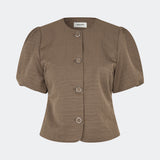 Moderne og feminin blazer. Cirkelmd SS blazer er fremstillet i 100% genanvendt nylon og designet med korte puffærmer, rund hals og markante knapdetaljer, der giver et sofistikeret udtryk. Perfekt som et stilfuldt statement-piece til både hverdag og særlige anledninger.