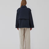 Kort trenchcoat i mørkeblå i bomuldskvalitet med skjult knaplukning fortil. Clara jacket har en oversize silhuet og klassiske detaljer. Med for.