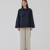 Kort trenchcoat i mørkeblå i bomuldskvalitet med skjult knaplukning fortil. Clara jacket har en oversize silhuet og klassiske detaljer. Med for.