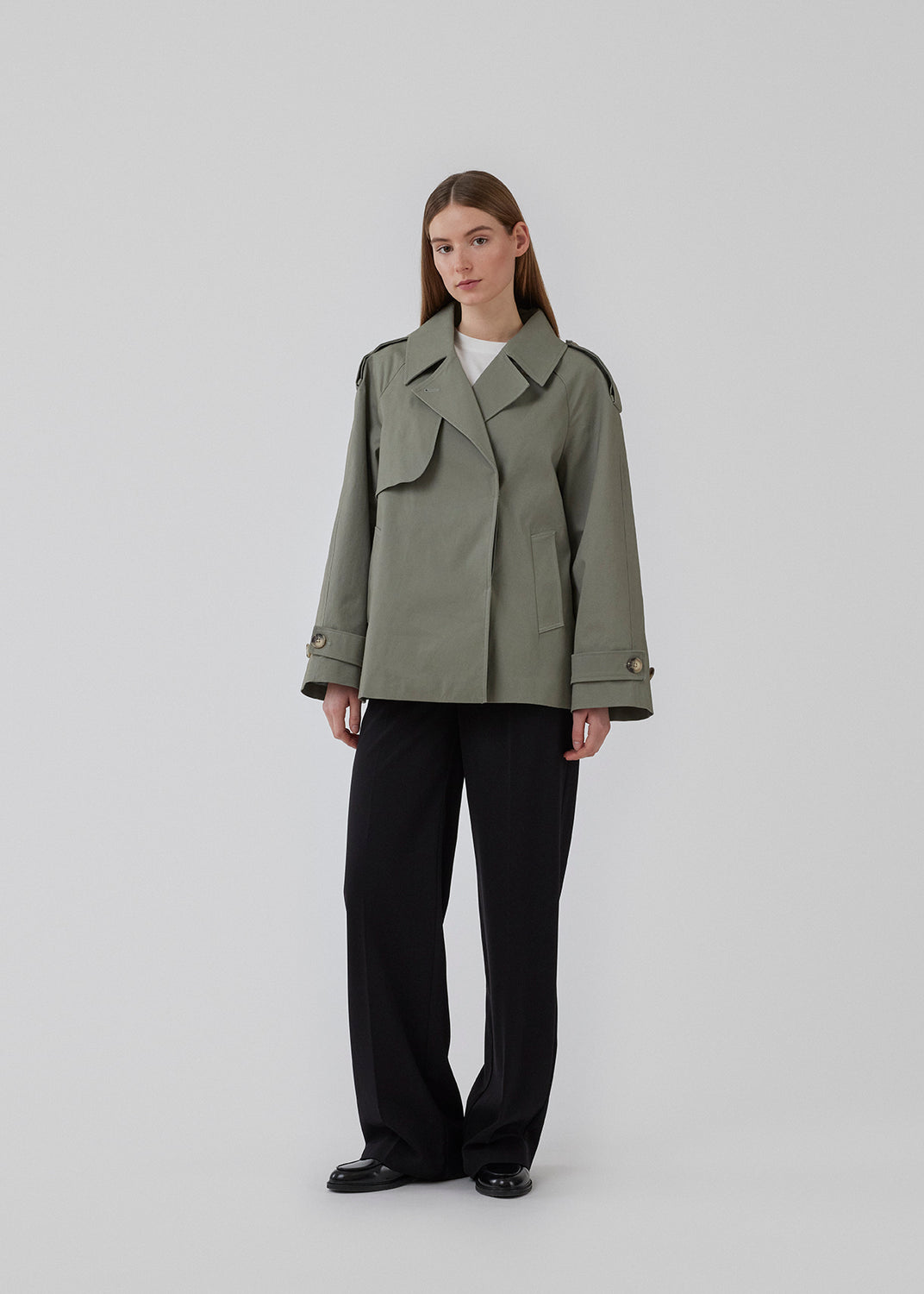 Kort trenchcoat i sart, lys grøn i bomuldskvalitet med skjult knaplukning fortil. Clara jacket har en oversize silhuet og klassiske detaljer. Med for. Modellen er 177 cm og har en størrelse S