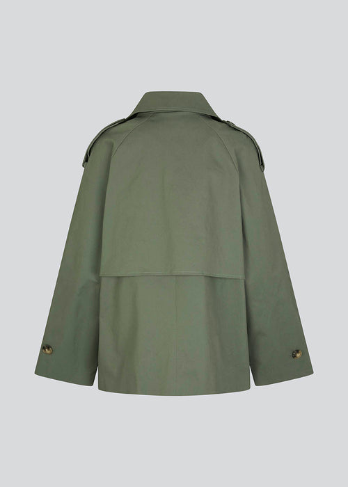 Kort trenchcoat i sart, lys grøn i bomuldskvalitet med skjult knaplukning fortil. Clara jacket har en oversize silhuet og klassiske detaljer. Med for. Modellen er 177 cm og har en størrelse S/36 på.