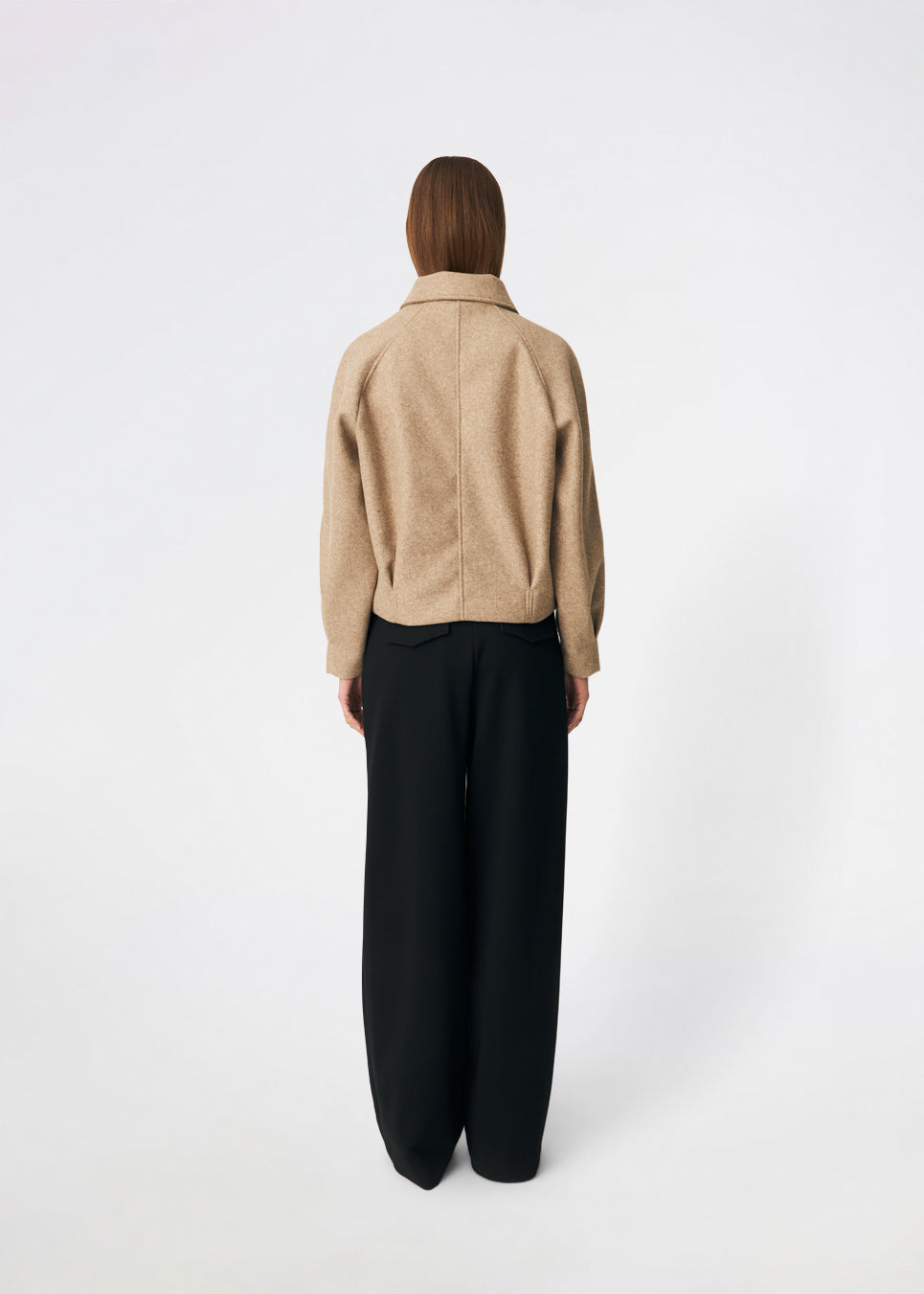 Kort uldjakke med et tidløst og sofistikeret udtryk. Cleamd jacket har en afslappet, let boxy silhuet med dobbeltradet knaplukning, klassisk krave og raglanærmer, der giver et blødt og komfortabelt fit. Diskrete stiklommer og rene linjer understreger det minimalistiske design, mens den korte længde gør jakken ideel til både hverdagsbrug og mere elegante outfits.
