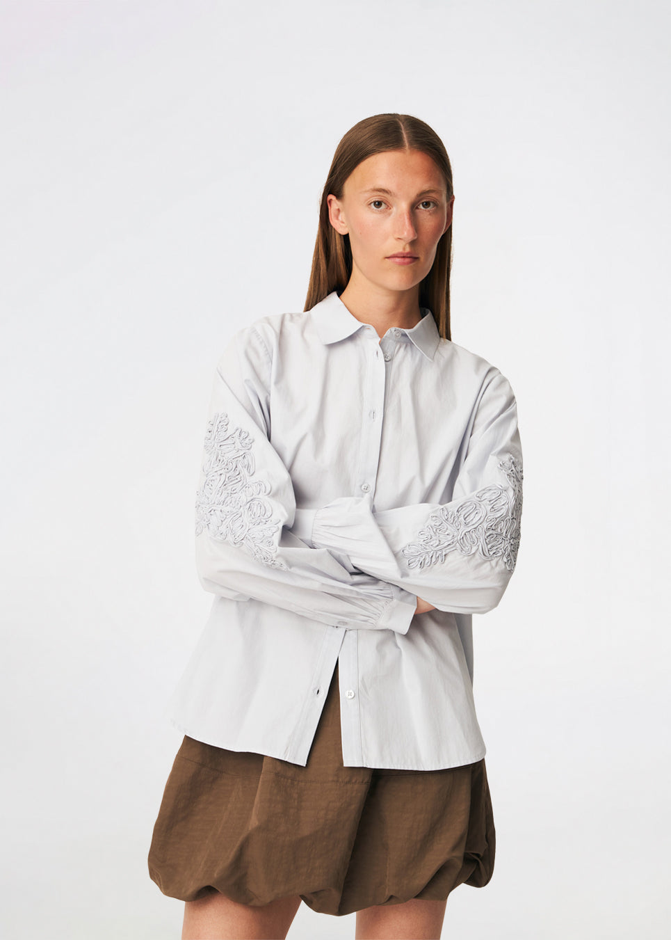ColumbusMD Shirt er en skjorte med løs pasform og klassisk krave. Designet har gennemgående knaplukning, lange ærmer med manchetter og dekorative blomsterdetaljer langs ærmerne. Style den med jeans eller et par klassiske bukser til et enkelt hverdagslook. Modellen er 175 cm høj og bruger størrelse S/36.
 
