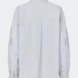 ColumbusMD Shirt er en skjorte med løs pasform og klassisk krave. Designet har gennemgående knaplukning, lange ærmer med manchetter og dekorative blomsterdetaljer langs ærmerne. Style den med jeans eller et par klassiske bukser til et enkelt hverdagslook. Modellen er 175 cm høj og bruger størrelse S/36.