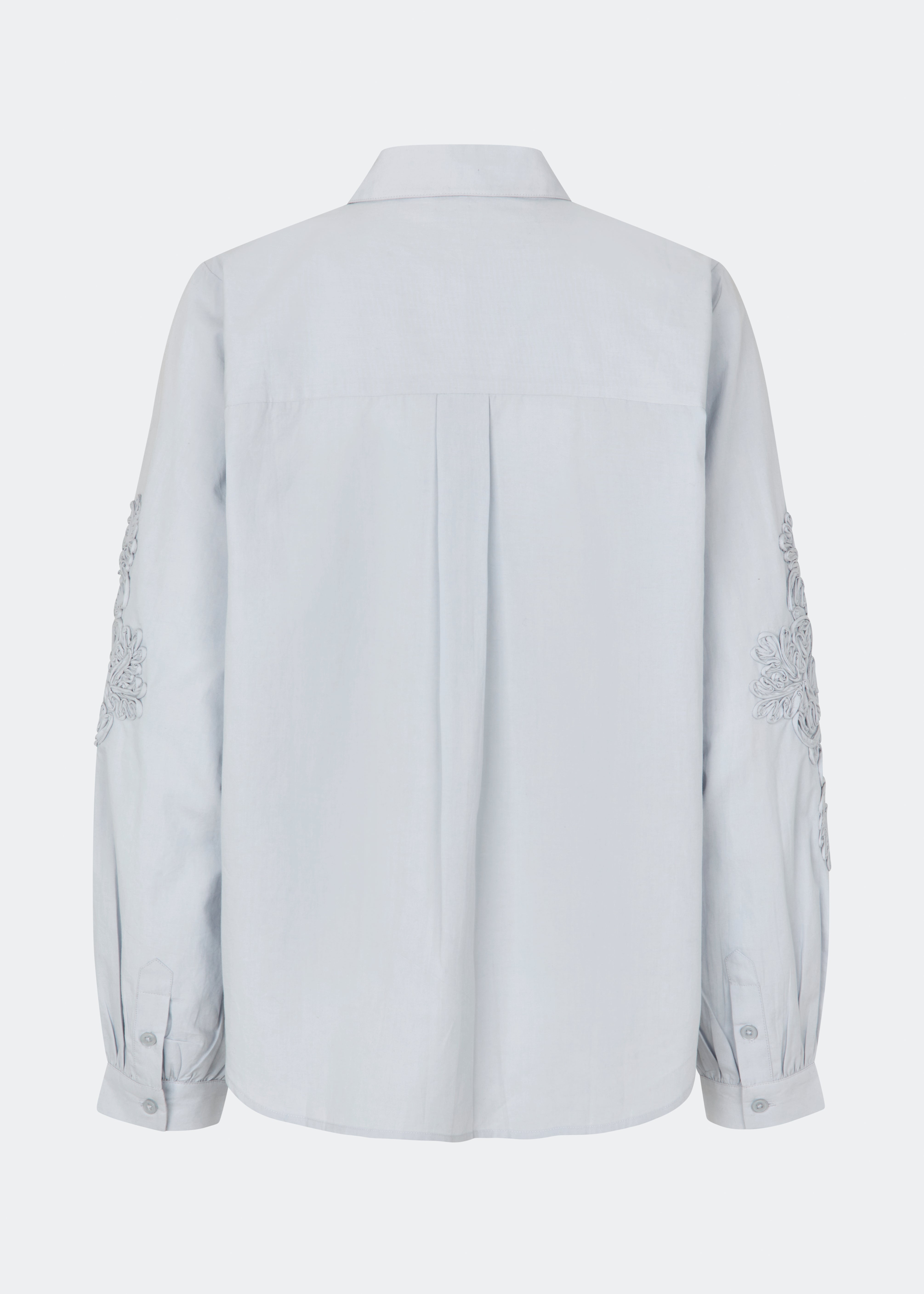 ColumbusMD Shirt er en skjorte med løs pasform og klassisk krave. Designet har gennemgående knaplukning, lange ærmer med manchetter og dekorative blomsterdetaljer langs ærmerne. Style den med jeans eller et par klassiske bukser til et enkelt hverdagslook. Modellen er 175 cm høj og bruger størrelse S/36.