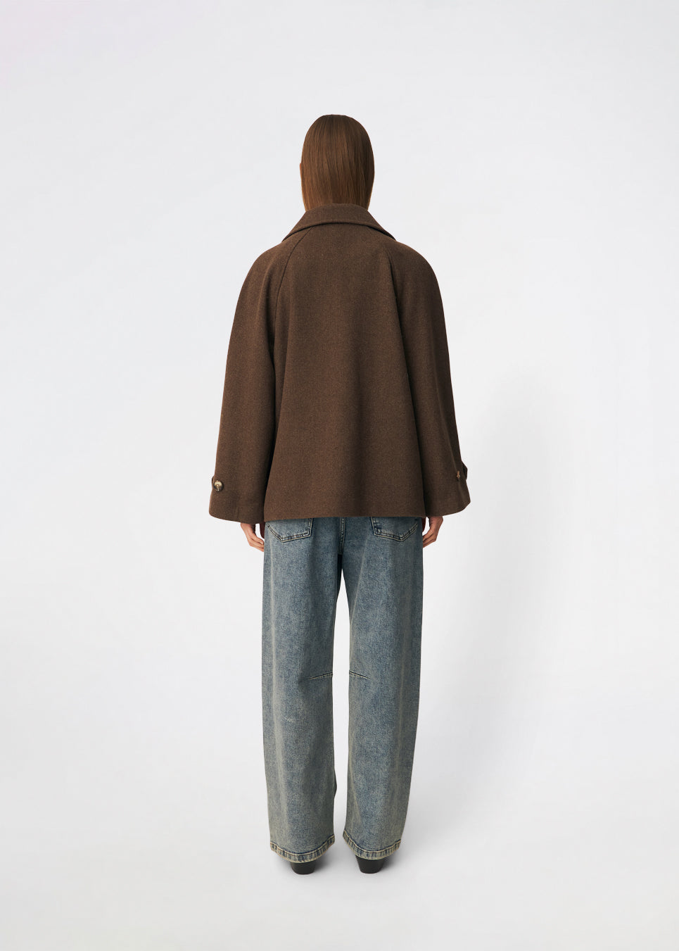 Kort dobbeltradet jakke i uldblanding. Brede revers og et bindebælte definerer formen, mens klaplommer afslutter fronten. Style den med bæltet lukket og jeans med lige ben eller åben over en flagrende kjole. Modellen er 175 cm høj og bruger størrelse S/36.