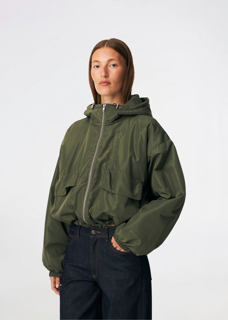 ConnieMD Jacket er en kort jakke med løs pasform og hætte. Jakken har lynlåslukning foran, store lommer med klap og lange, voluminøse ærmer med elastik ved håndleddene. Modellen er 175 cm høj og bruger størrelse S/36.