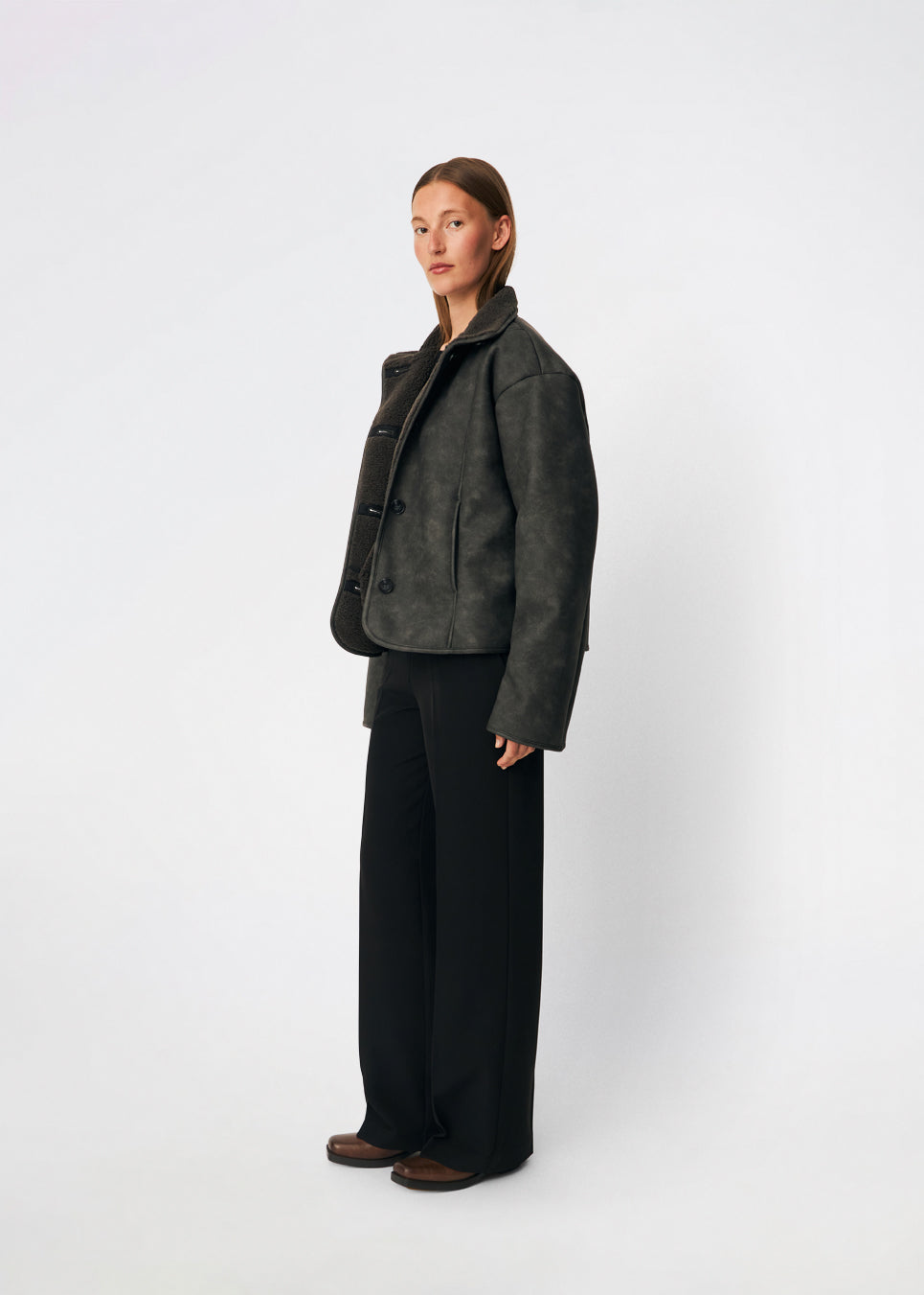 Kort jakke i imiteret rulam med et moderne og tidløst udtryk. Coralinemd jacket har en afslappet silhuet med høj ståkrave, knaplukning foran og dekorative syningsdetaljer, der fremhæver det klassiske design. De bløde teddykanter ved ærmerne tilfører varme og kontrast, mens den let oversized pasform gør jakken ideel til lag-på-lag styling gennem de kolde måneder.
