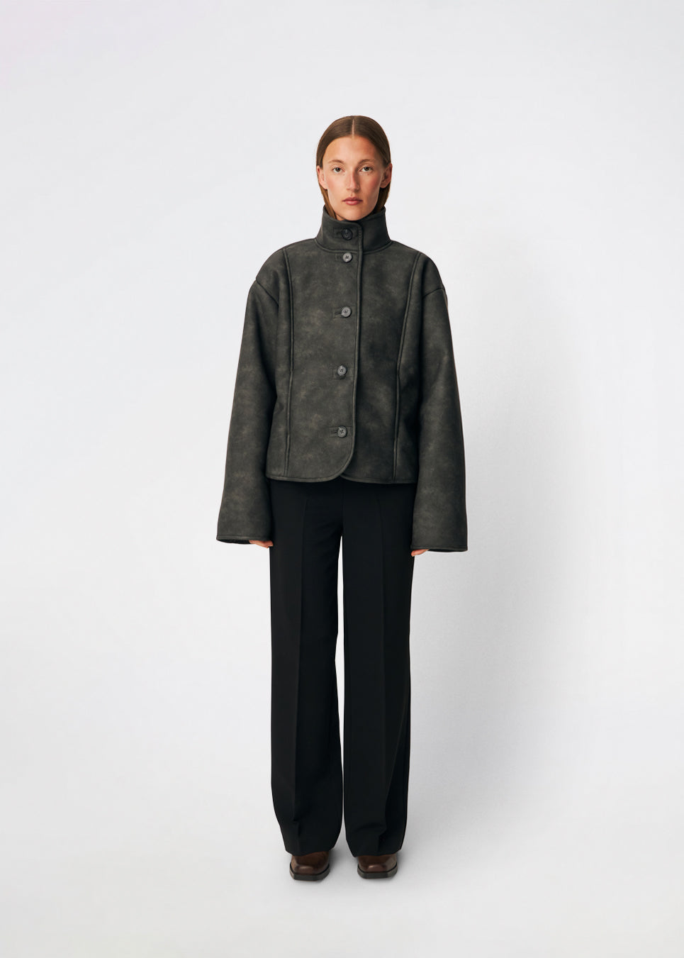 Kort jakke i imiteret rulam med et moderne og tidløst udtryk. Coralinemd jacket har en afslappet silhuet med høj ståkrave, knaplukning foran og dekorative syningsdetaljer, der fremhæver det klassiske design. De bløde teddykanter ved ærmerne tilfører varme og kontrast, mens den let oversized pasform gør jakken ideel til lag-på-lag styling gennem de kolde måneder.