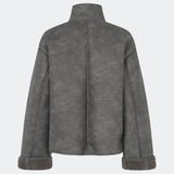Kort jakke i imiteret rulam med et moderne og tidløst udtryk. Coralinemd jacket har en afslappet silhuet med høj ståkrave, knaplukning foran og dekorative syningsdetaljer, der fremhæver det klassiske design. De bløde teddykanter ved ærmerne tilfører varme og kontrast, mens den let oversized pasform gør jakken ideel til lag-på-lag styling gennem de kolde måneder.