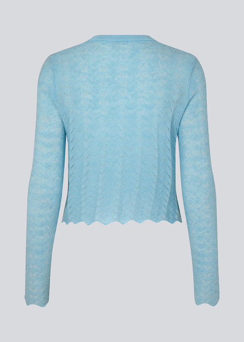 Strikket trøje i lyseblå med hulmønster i let kvalitet med uld. CordellMD short o-neck har en afslappet cropped pasform og lange ærmer med bølgede kanter. Modellen er 175 cm og har en størrelse S/36 på.