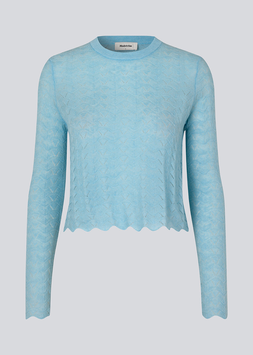 Strikket trøje i lyseblå med hulmønster i let kvalitet med uld. CordellMD short o-neck har en afslappet cropped pasform og lange ærmer med bølgede kanter. Modellen er 175 cm og har en størrelse S/36 på.