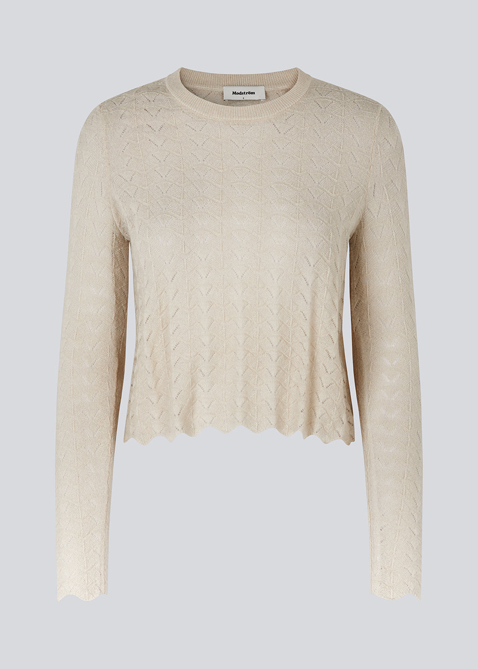 Strikket trøje i beige med hulmønster i let kvalitet med uld. CordellMD short o-neck har en afslappet cropped pasform og lange ærmer med bølgede kanter. Modellen er 175 cm og har en størrelse S/36 på.