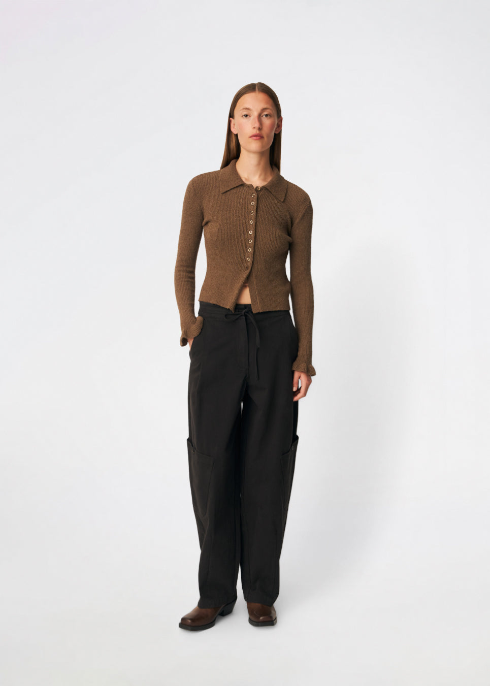 Feminin ribstrikket cardigan med elegante detaljer. Corneliamd cardigan er designet i en tætsiddende silhuet med klassisk krave, gennemgående knaplukning og fine flæsekantdetaljer ved manchetterne. 