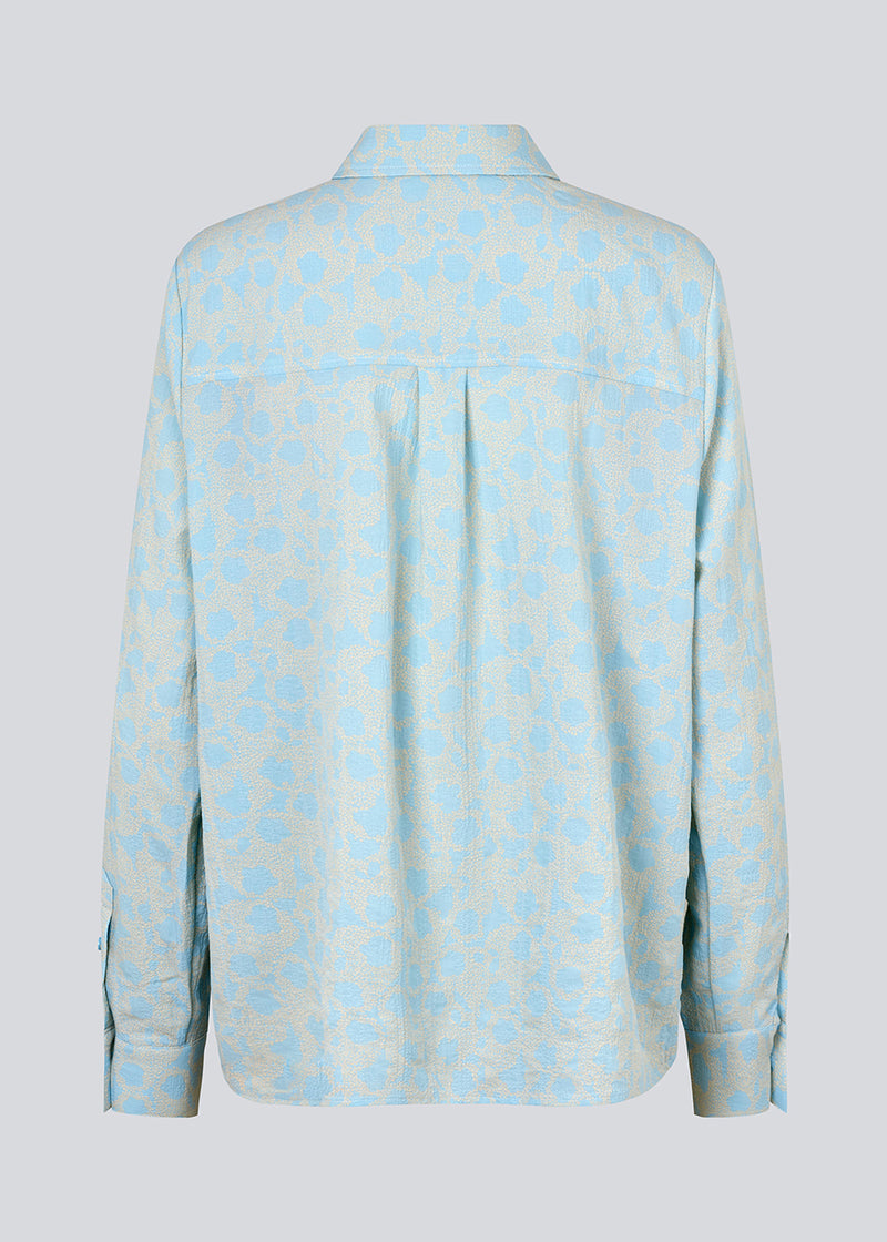 CupidMD print shirt i lyseblå er en skjorte af genanvendt polyester. Det er en afslappet skjorte med fint blomsterprint.  Modellen er 177 cm og har en størrelse S/36 på.