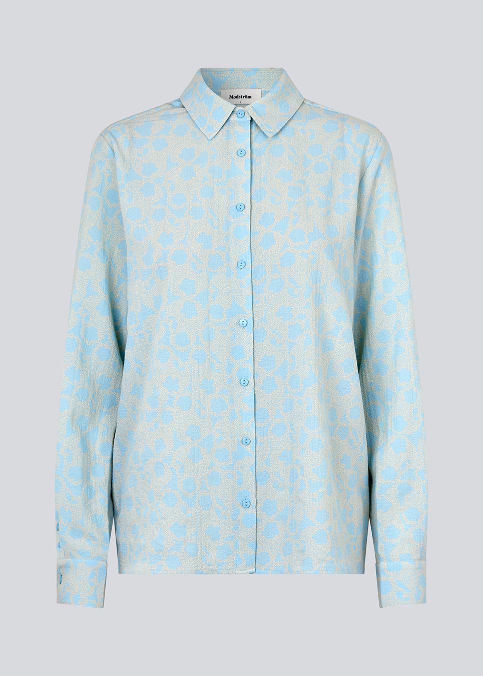 CupidMD print shirt i lyseblå er en skjorte af genanvendt polyester. Det er en afslappet skjorte med fint blomsterprint.  Modellen er 177 cm og har en størrelse S/36 på.