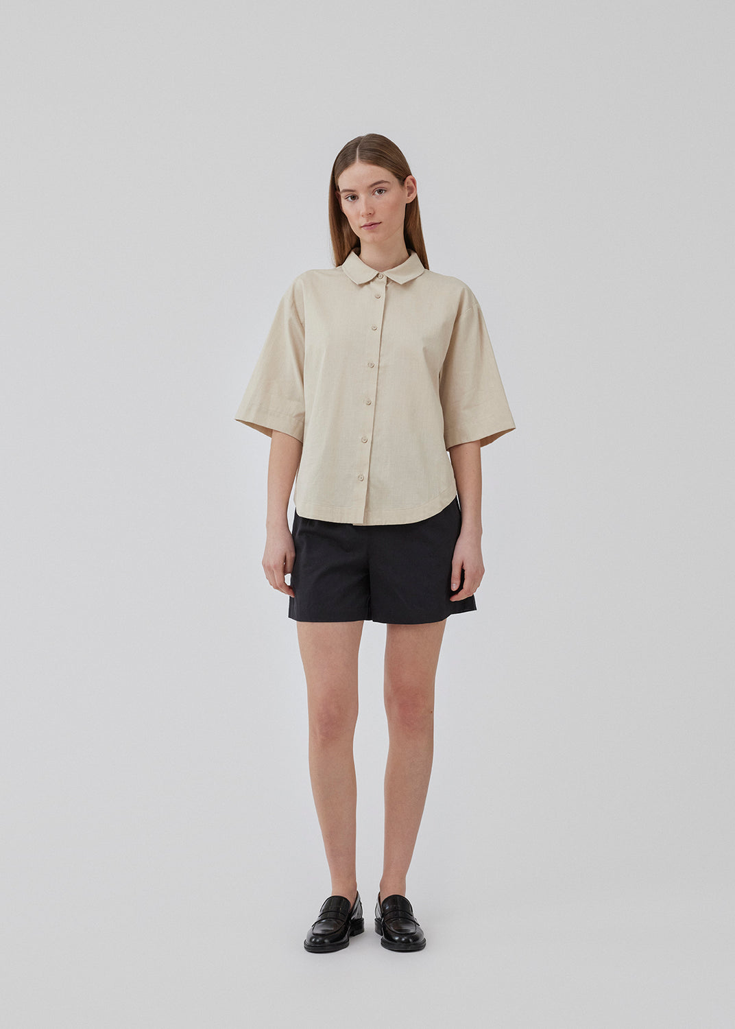 Kort, oversized skjorte i beige i bomuld. CydneyMD ss shirt har krave, knaplukning fortil og afrundede kanter forneden. Lav skuldersøm og korte ærmer. Modellen er 175 cm og har en størrelse S/36 på.
