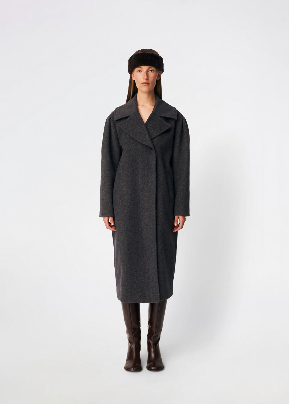 Cyllemd Coat er en lang, oversized frakke med et tidløst og minimalistisk udtryk. Frakken er designet med brede revers, skjult knaplukning og diskrete paspolerede lommer, som giver et rent og sofistikeret look. Den afslappede silhuet gør den nem at style over både skræddersyede outfits og afslappede hverdagslooks, mens den bløde uldblanding sikrer komfort gennem hele sæsonen.