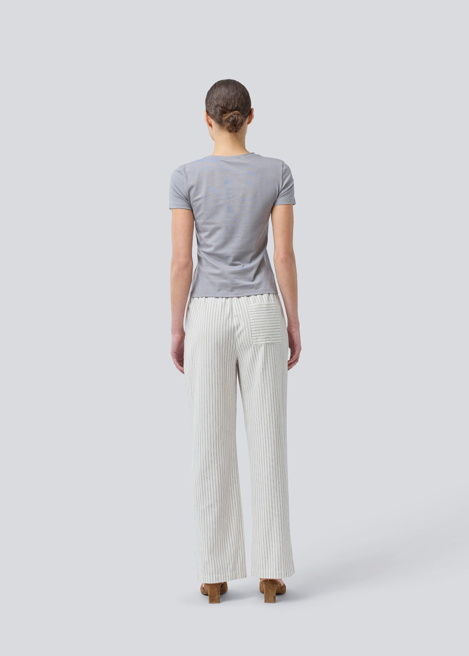 Tætsiddende basic top med høj og lige udskæring i halsen i grå. DaeMD top er fremstillet i en ribstrikket økologisk bomuld. Modellen er 177 cm og har en størrelse S/36 på.