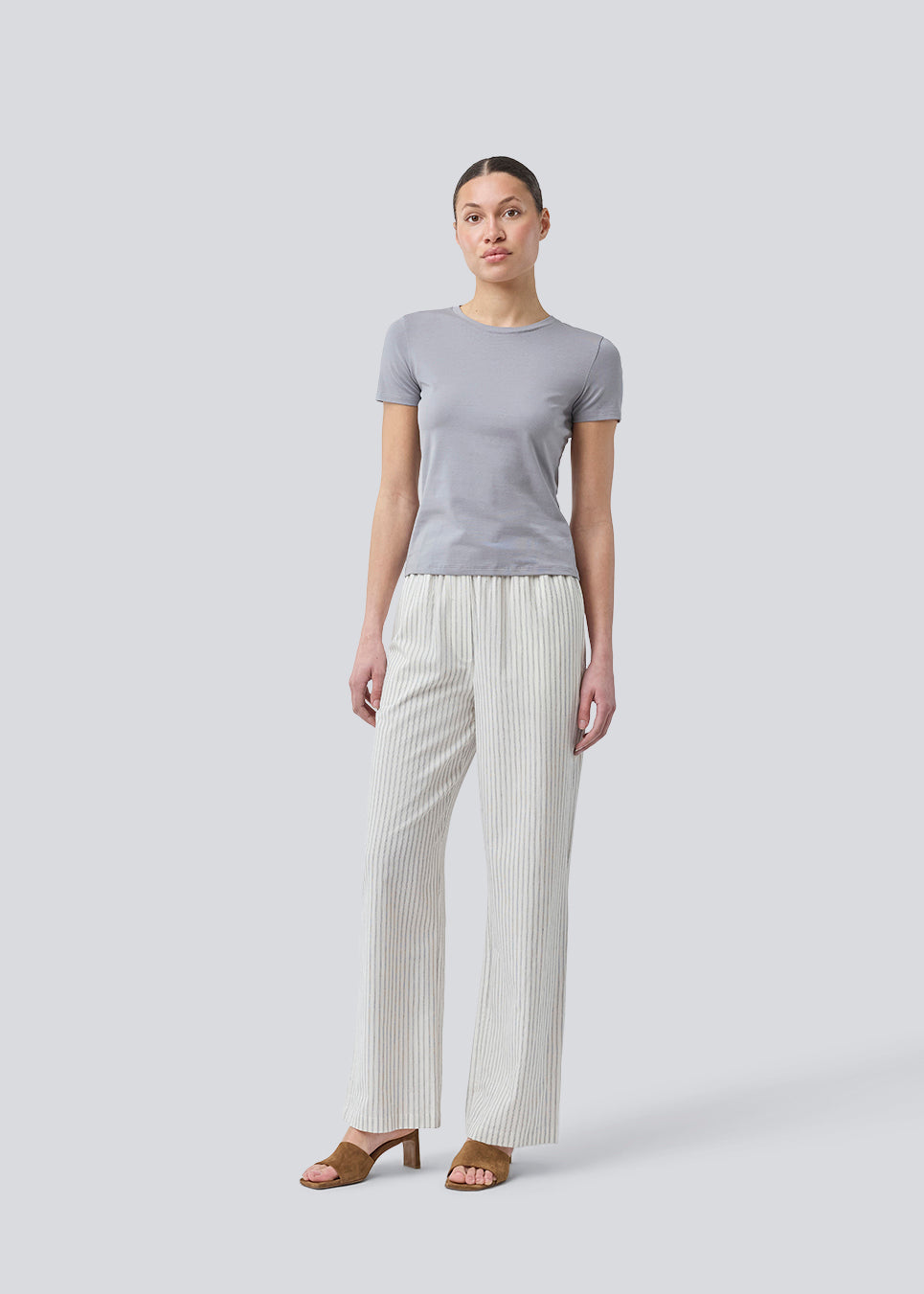 Tætsiddende basic top med høj og lige udskæring i halsen i grå. DaeMD top er fremstillet i en ribstrikket økologisk bomuld. Modellen er 177 cm og har en størrelse S/36 på.