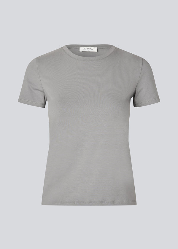 Tætsiddende basic top med høj og lige udskæring i halsen i grå. DaeMD top er fremstillet i en ribstrikket økologisk bomuld. Modellen er 177 cm og har en størrelse S/36 på.