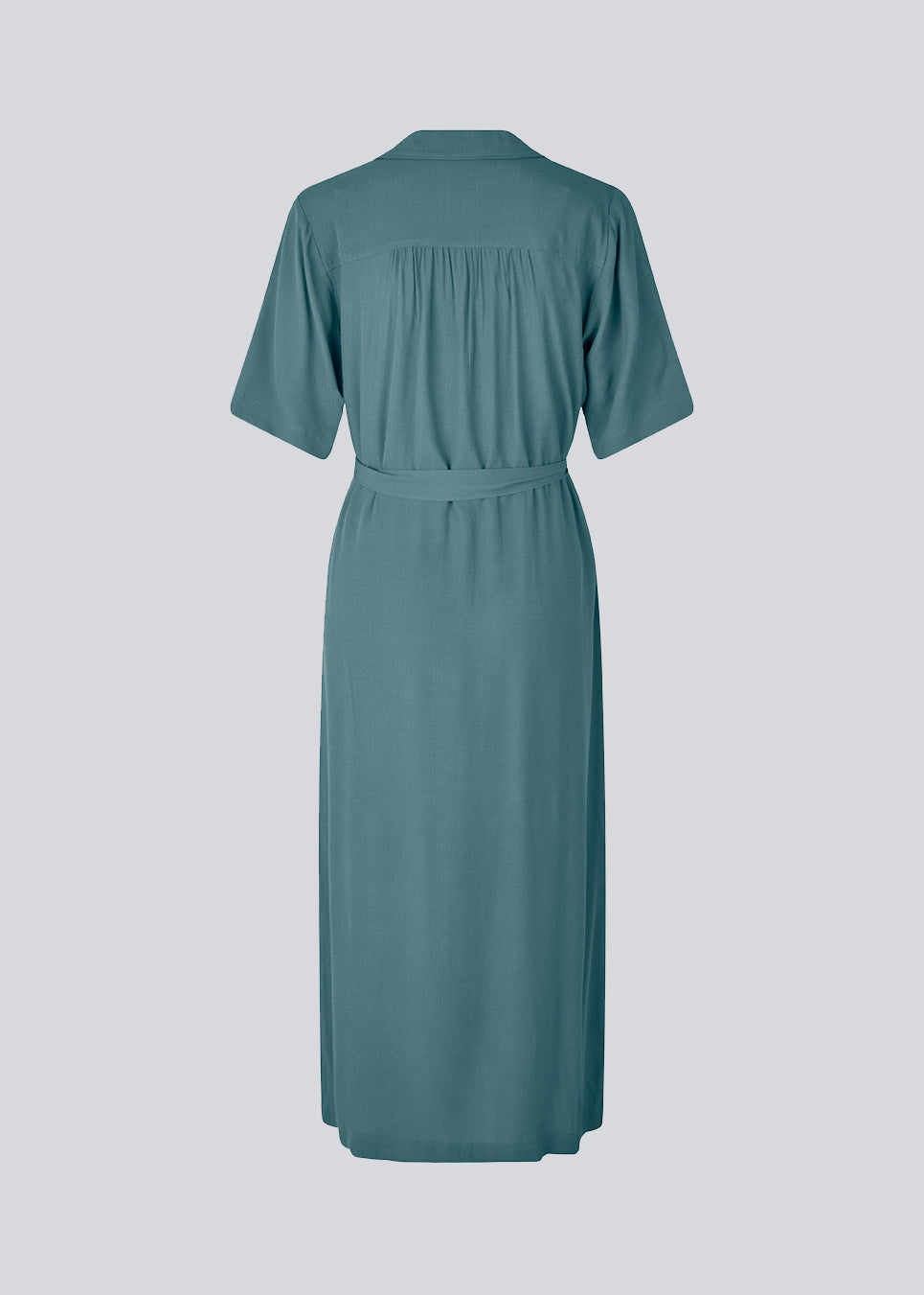 Afslappet skjortekjole i blå i EcoVero viskose. DafneMD long dress har resort krave, knaplukning fortil, bindebælte i taljen og korte ærmer. Modellen er 177 cm og har en størrelse S/36 på.