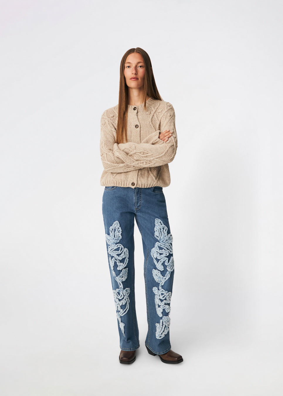 DahliaMD Cardigan er en kort cardigan med løs pasform og rund hals. Designet har gennemgående knaplukning, lange ærmer og dekorative strikdetaljer foran og langs ærmerne. Style den med jeans eller klassiske bukser til et afslappet hverdagslook. Modellen er 175 cm høj og bruger størrelse S/36.