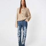 DahliaMD Cardigan er en kort cardigan med løs pasform og rund hals. Designet har gennemgående knaplukning, lange ærmer og dekorative strikdetaljer foran og langs ærmerne. Style den med jeans eller klassiske bukser til et afslappet hverdagslook. Modellen er 175 cm høj og bruger størrelse S/36.