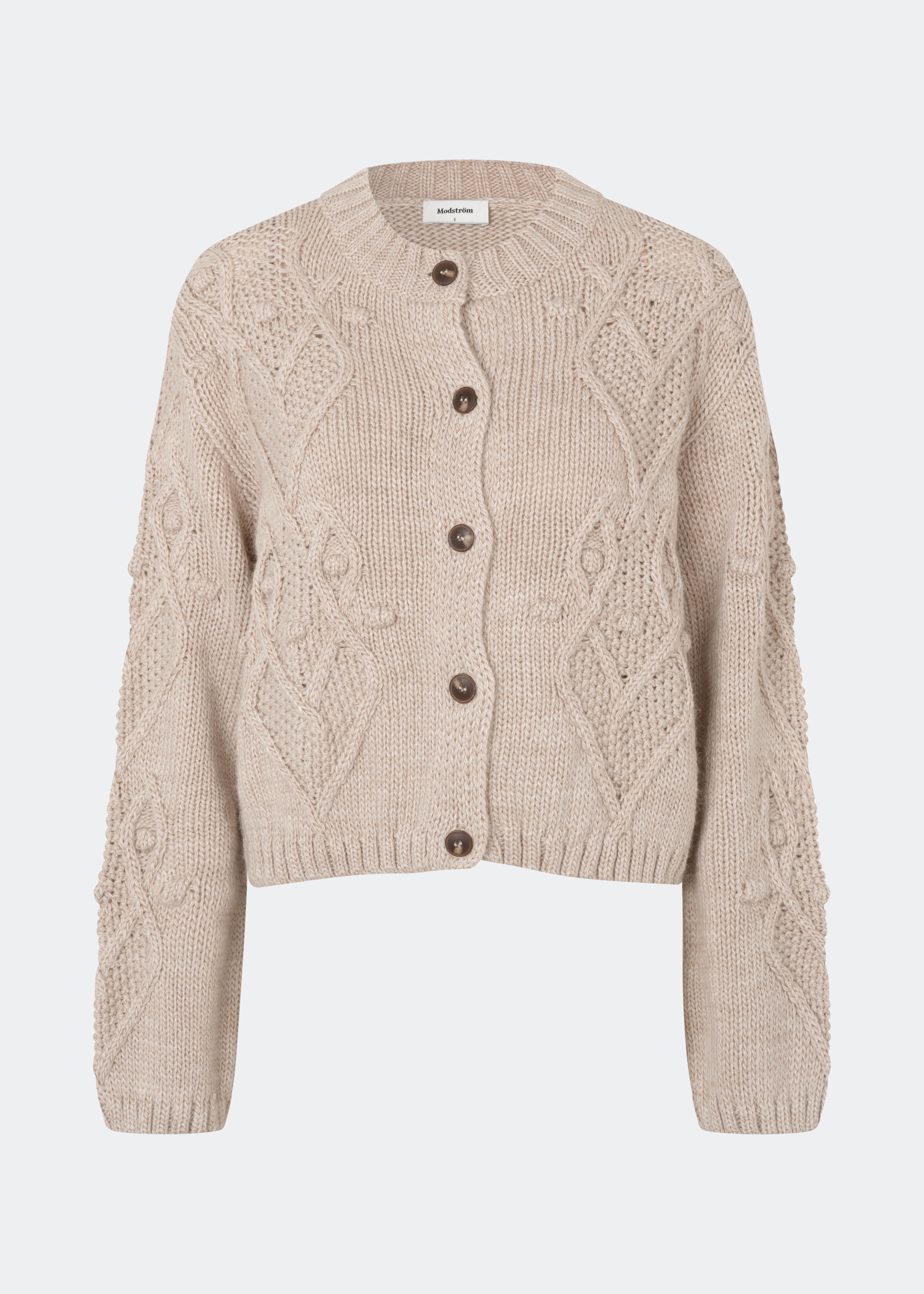 DahliaMD Cardigan er en kort cardigan med løs pasform og rund hals. Designet har gennemgående knaplukning, lange ærmer og dekorative strikdetaljer foran og langs ærmerne. Style den med jeans eller klassiske bukser til et afslappet hverdagslook. Modellen er 175 cm høj og bruger størrelse S/36.