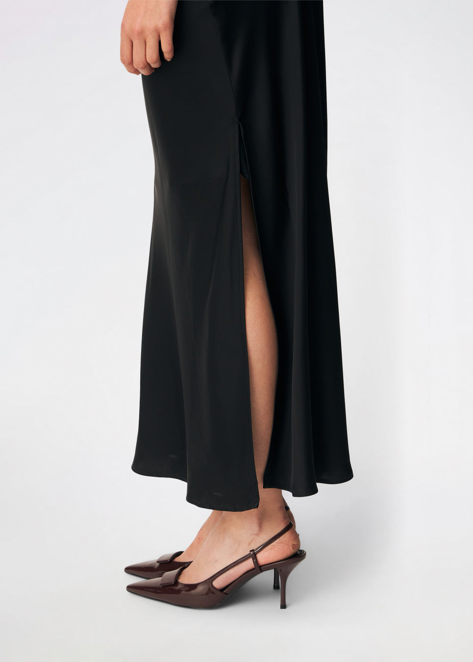 DanillaMD Dress er en lang satin-kjole med en elegant, figurnær silhuet. Designet har en lige halsudskæring, tynde stropper og draperede detaljer i siden, som skaber et blødt fald. Den åbne ryg med fine krydsende stropper tilfører et feminint udtryk. Style den med hæle og enkle accessories til særlige anledninger. Modellen er 175 cm høj og bruger størrelse S/36.