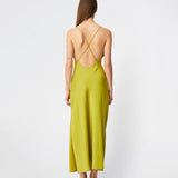 DanillaMD Dress er en lang satin-kjole med en elegant, figurnær silhuet. Designet har en lige halsudskæring, tynde stropper og draperede detaljer i siden, som skaber et blødt fald. Den åbne ryg med fine krydsende stropper tilfører et feminint udtryk. Style den med hæle og enkle accessories til særlige anledninger. Modellen er 175 cm høj og bruger størrelse S/36.
