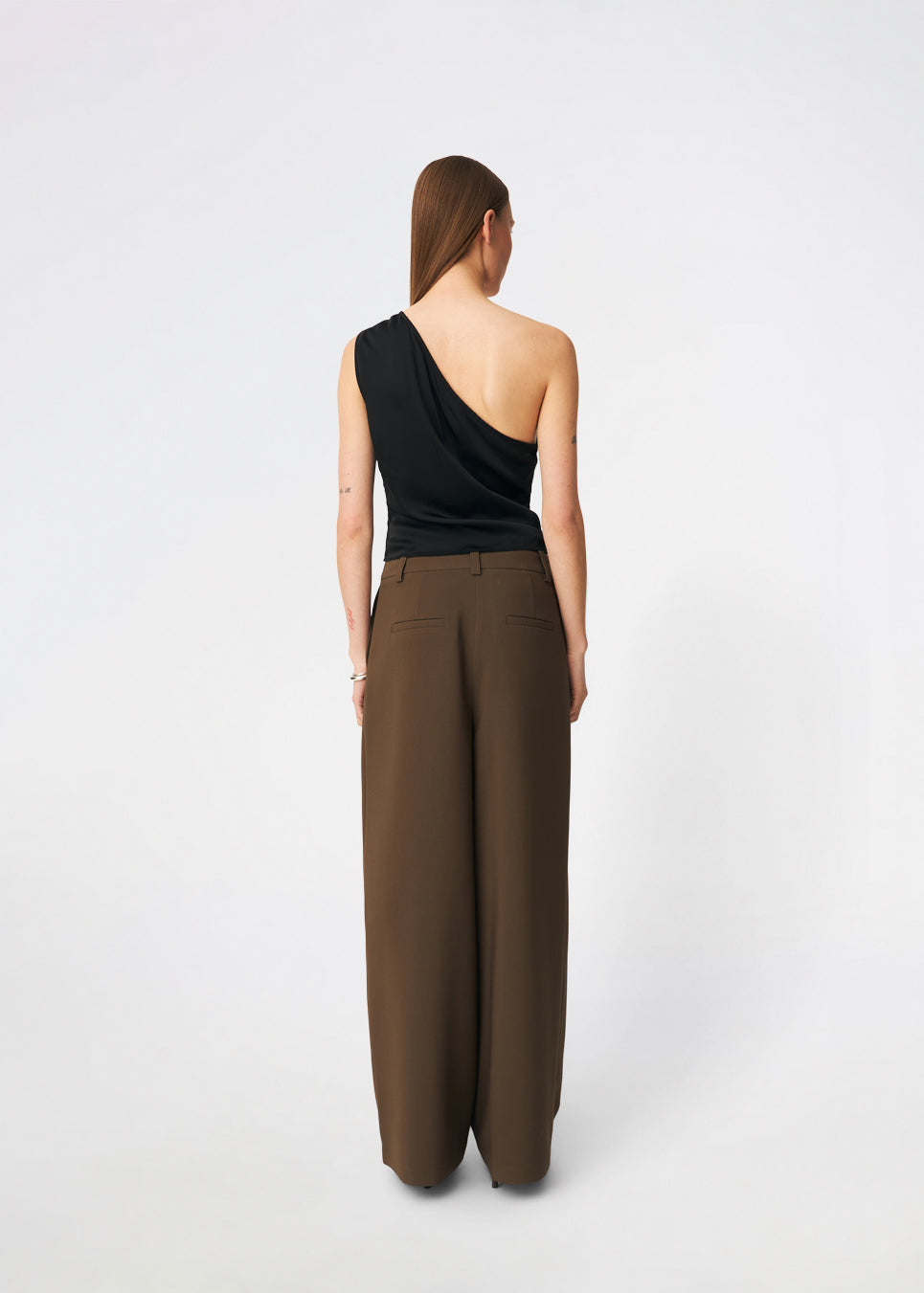 DanillaMD Top er en asymmetrisk satin-top med en tætsiddende silhuet og én skulder. Designet har bløde draperinger og bindebånd i siden, som skaber en feminin detalje og giver mulighed for at justere pasformen. Style den med skræddersyede bukser eller en lang nederdel til både hverdag og særlige anledninger. Modellen er 175 cm høj og bruger størrelse S/36.
