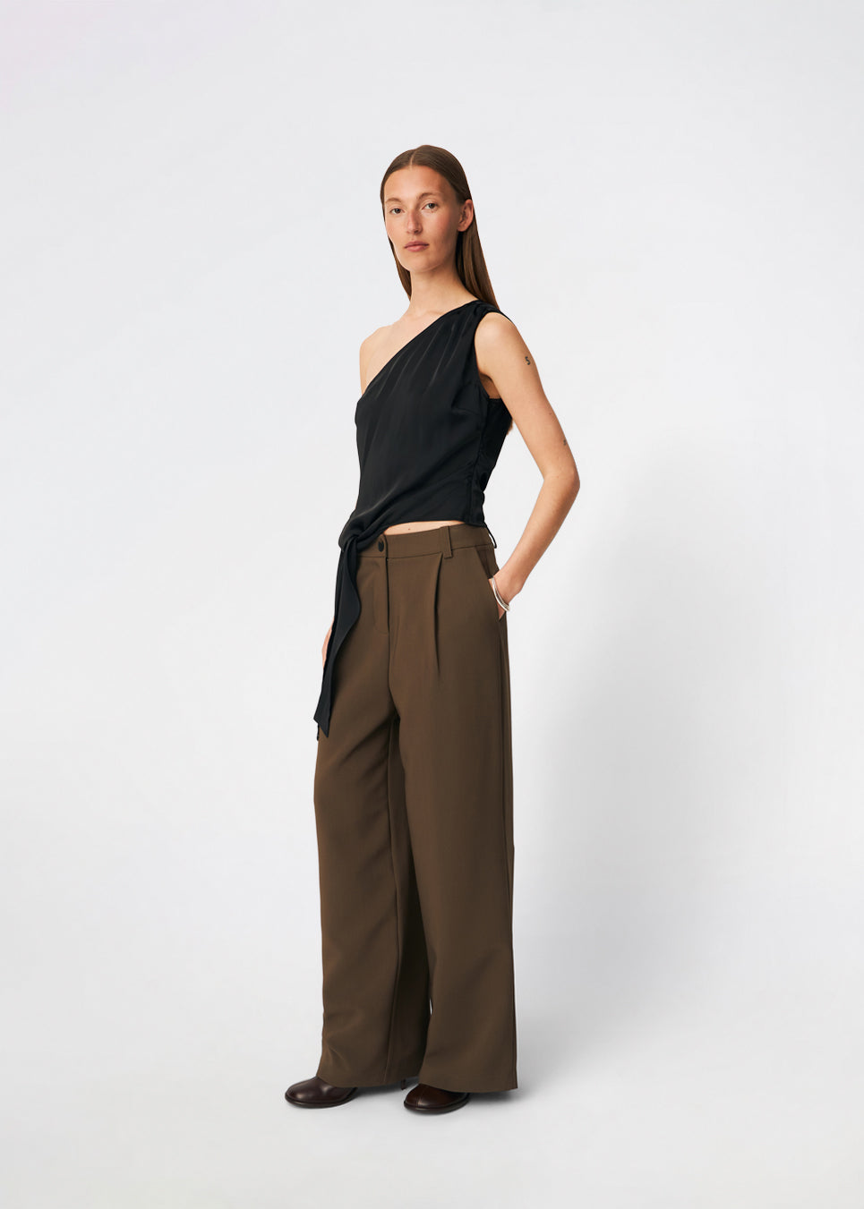 DanillaMD Top er en asymmetrisk satin-top med en tætsiddende silhuet og én skulder. Designet har bløde draperinger og bindebånd i siden, som skaber en feminin detalje og giver mulighed for at justere pasformen. Style den med skræddersyede bukser eller en lang nederdel til både hverdag og særlige anledninger. Modellen er 175 cm høj og bruger størrelse S/36.