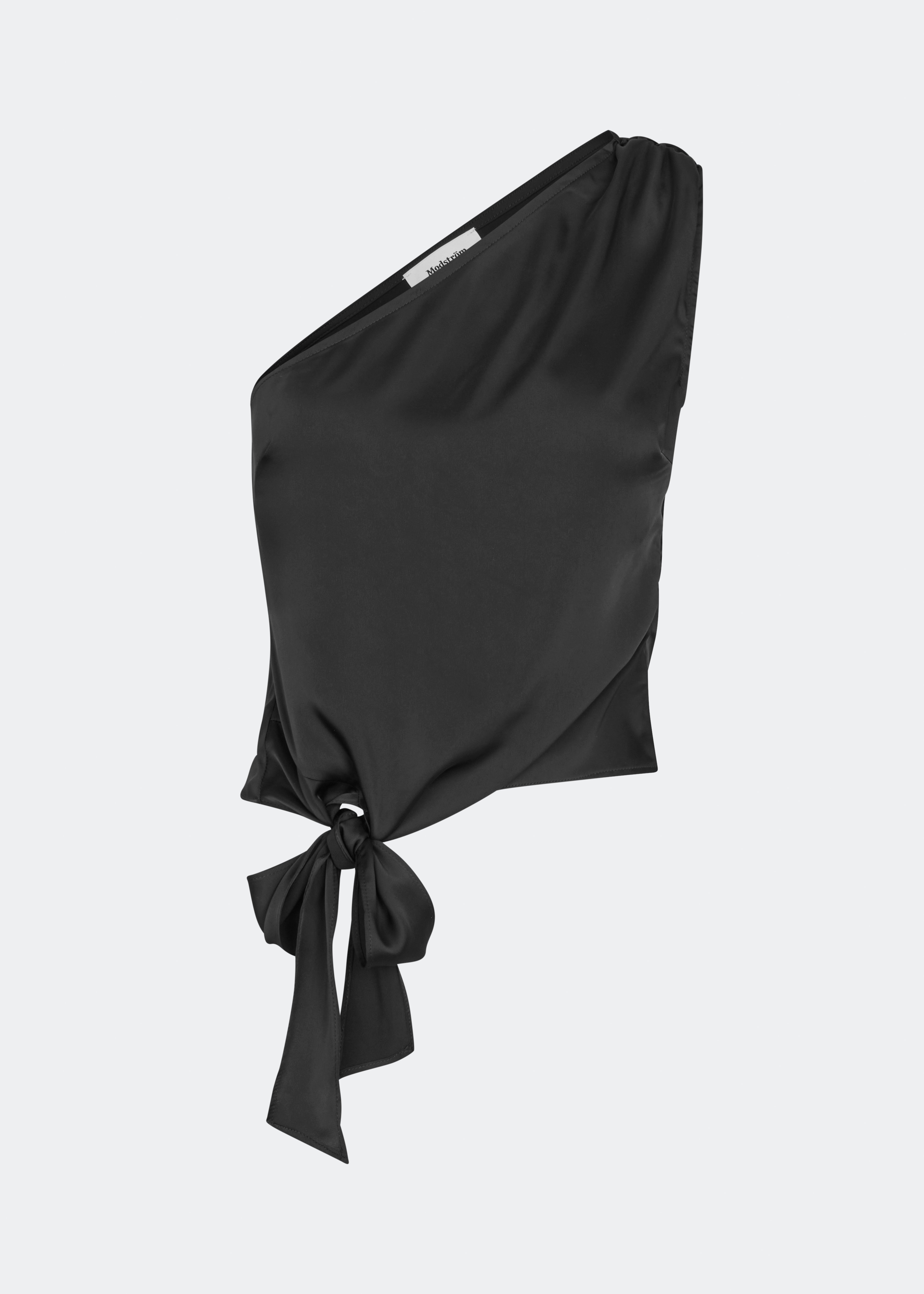 DanillaMD Top er en asymmetrisk satin-top med en tætsiddende silhuet og én skulder. Designet har bløde draperinger og bindebånd i siden, som skaber en feminin detalje og giver mulighed for at justere pasformen. Style den med skræddersyede bukser eller en lang nederdel til både hverdag og særlige anledninger. Modellen er 175 cm høj og bruger størrelse S/36.
