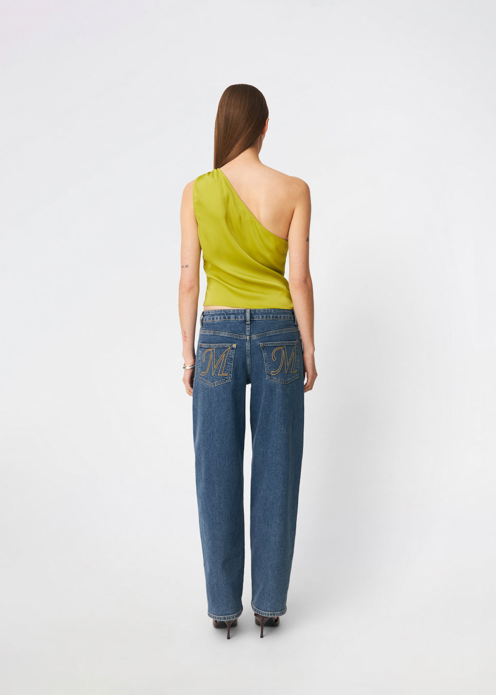 DanillaMD Top er en asymmetrisk satin-top med en tætsiddende silhuet og én skulder. Designet har bløde draperinger og bindebånd i siden, som skaber en feminin detalje og giver mulighed for at justere pasformen. Style den med skræddersyede bukser eller en lang nederdel til både hverdag og særlige anledninger. Modellen er 175 cm høj og bruger størrelse S/36.