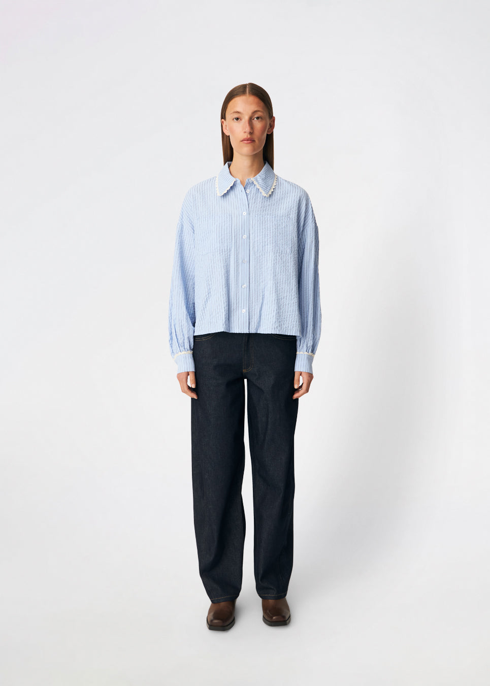 DanjaMD Shirt er en stribet skjorte med en afslappet pasform og lange ærmer. Designet har klassisk skjortekrave med dekorativ blondekant, knaplukning foran og to brystlommer. Blondekanter ved manchetterne tilfører en feminin kontrast til det klassiske stribede udtryk. Style den med jeans eller skræddersyede bukser til hverdagsbrug. Modellen er 175 cm høj og bruger størrelse S/36.