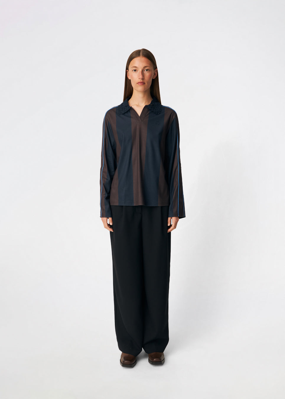 DannieMD Polo er en langærmet polo med en afslappet pasform og brede, vertikale striber. Designet har en dekorativ blondekrave, V-udskæring og kontrastfarvet piping langs ærmerne, som tilfører et sporty element. Style den med jeans eller løse bukser for et afslappet hverdagslook. Modellen er 175 cm høj og bruger størrelse S/36.