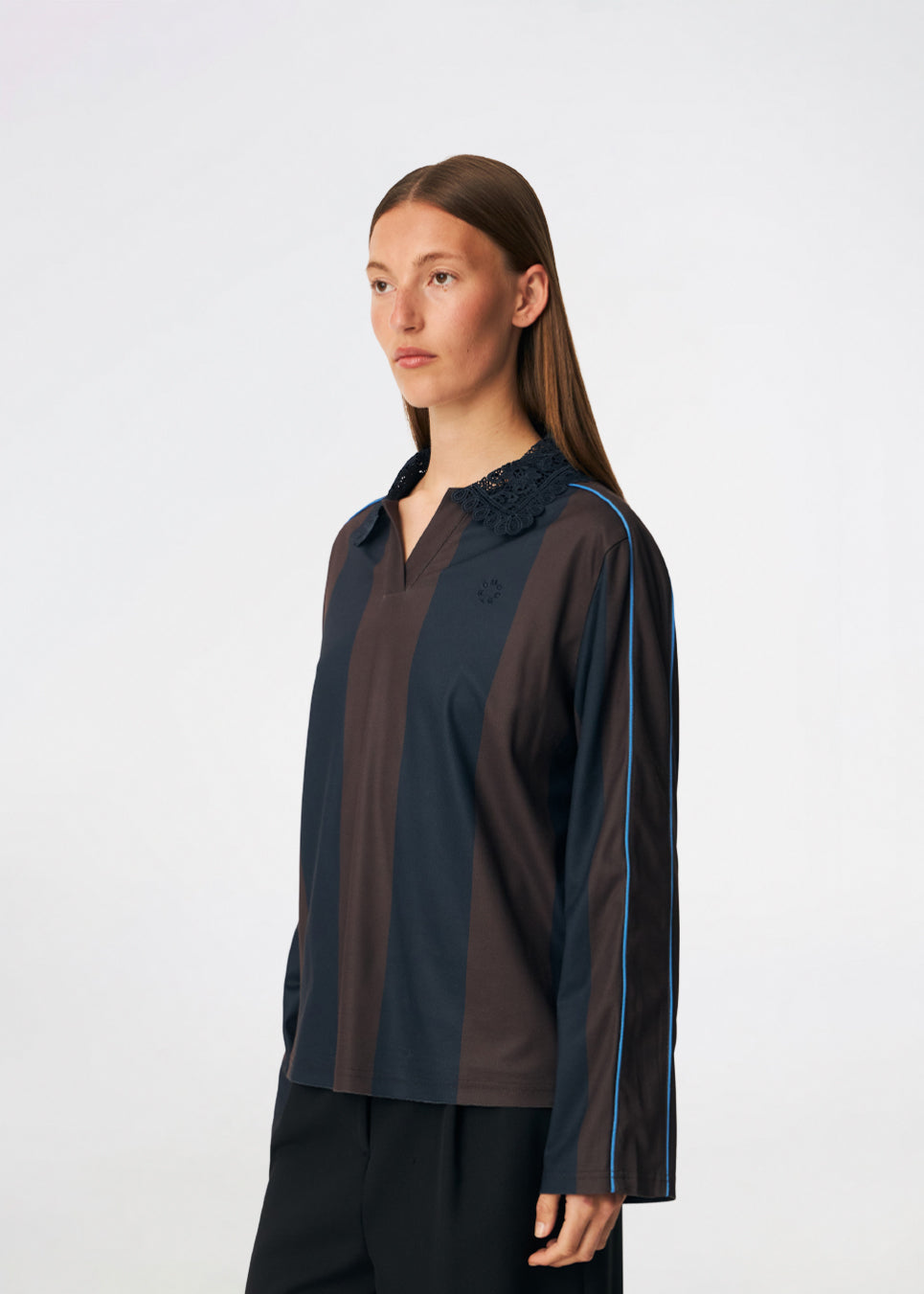 DannieMD Polo er en langærmet polo med en afslappet pasform og brede, vertikale striber. Designet har en dekorativ blondekrave, V-udskæring og kontrastfarvet piping langs ærmerne, som tilfører et sporty element. Style den med jeans eller løse bukser for et afslappet hverdagslook. Modellen er 175 cm høj og bruger størrelse S/36.