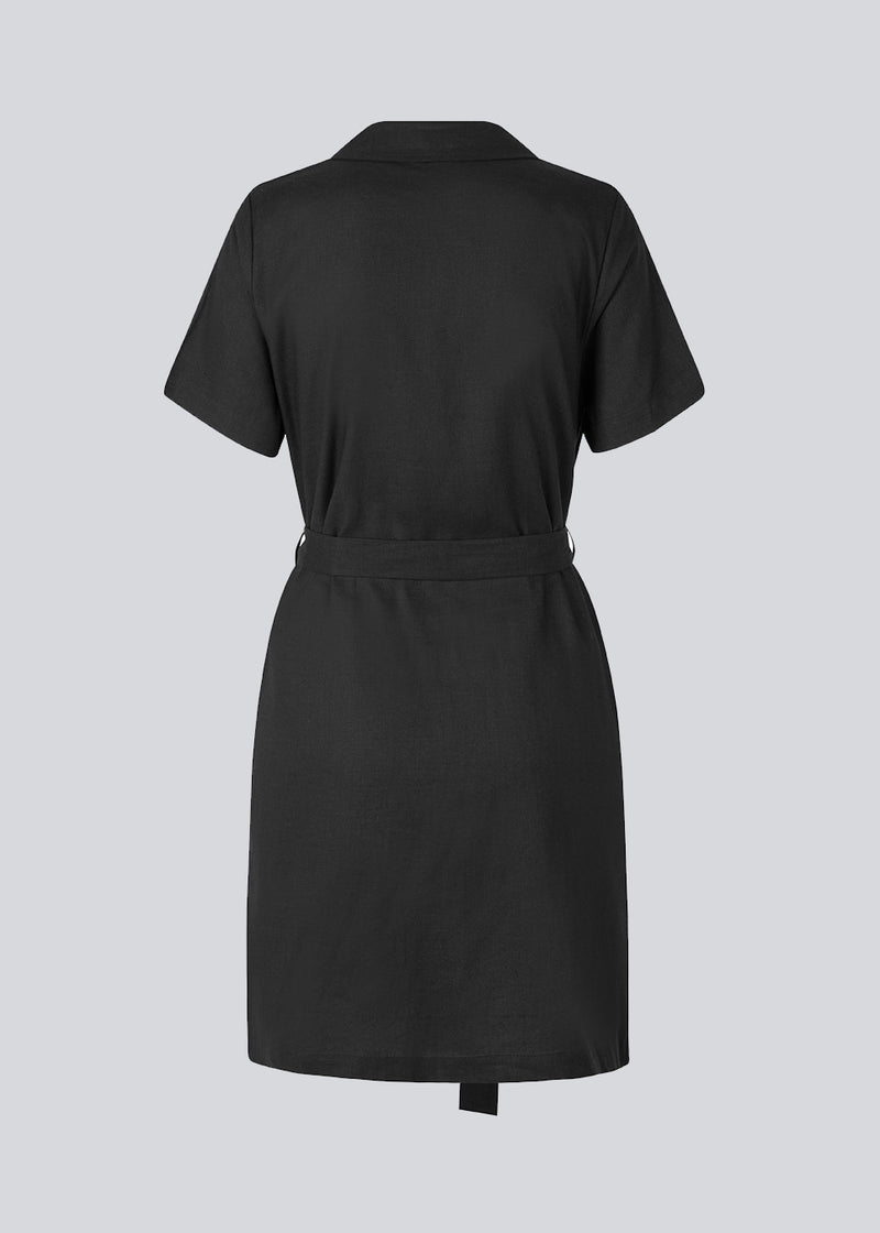 Afslappet skjortekjole i sort i hørkvalitet. DarrelMD dress har resortkrave, korte ærmer, knapper foran og bredt bindebælte i taljen. Modellen er 177 cm og har en størrelse S/36 på.