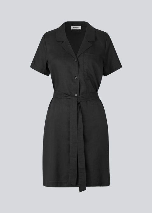 Afslappet skjortekjole i sort i hørkvalitet. DarrelMD dress har resortkrave, korte ærmer, knapper foran og bredt bindebælte i taljen. Modellen er 177 cm og har en størrelse S/36 på.