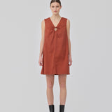 Kort mørkerød kjole i hørkvalitet med A-facon. DaynaMD dress er uden ærmer, med dyb v-udskæring med cut out-detalje og bindebånd. Modellen er 177 cm og har en størrelse S/36 på.