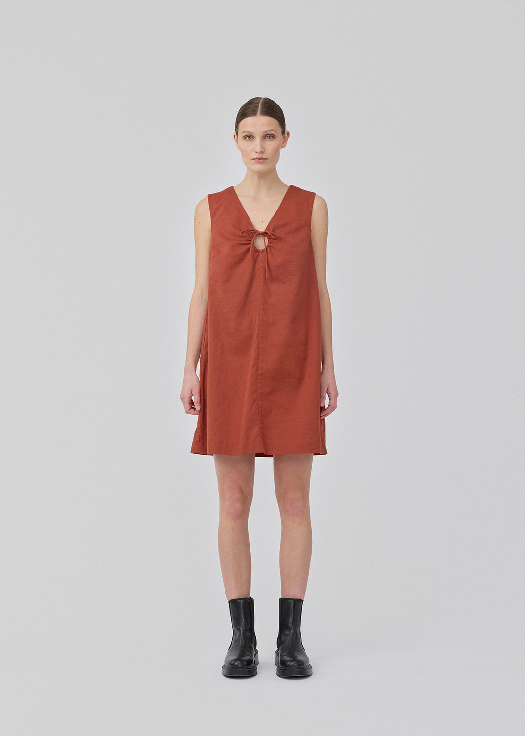 Kort mørkerød kjole i hørkvalitet med A-facon. DaynaMD dress er uden ærmer, med dyb v-udskæring med cut out-detalje og bindebånd. Modellen er 177 cm og har en størrelse S/36 på.