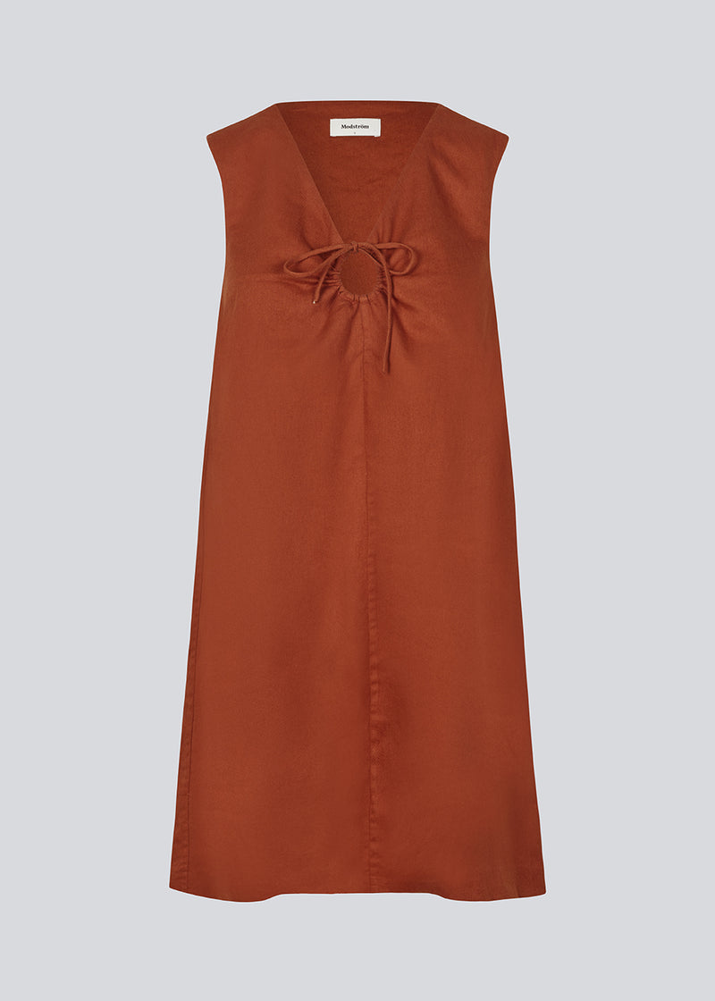 Kort mørkerød kjole i hørkvalitet med A-facon. DaynaMD dress er uden ærmer, med dyb v-udskæring med cut out-detalje og bindebånd. Modellen er 177 cm og har en størrelse S/36 på.