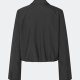 DeanneMD Blazer er en kort blazer med en afslappet, moderne silhuet. Blazeren har klassisk revers, lange ærmer, to knapper foran og elastisk kant forneden, der giver den skræddersyede style et mere casual udtryk. Style den med matchende bukser for et komplet suit-look eller med jeans for en mere afslappet styling. Modellen er 175 cm høj og bruger størrelse S/36.