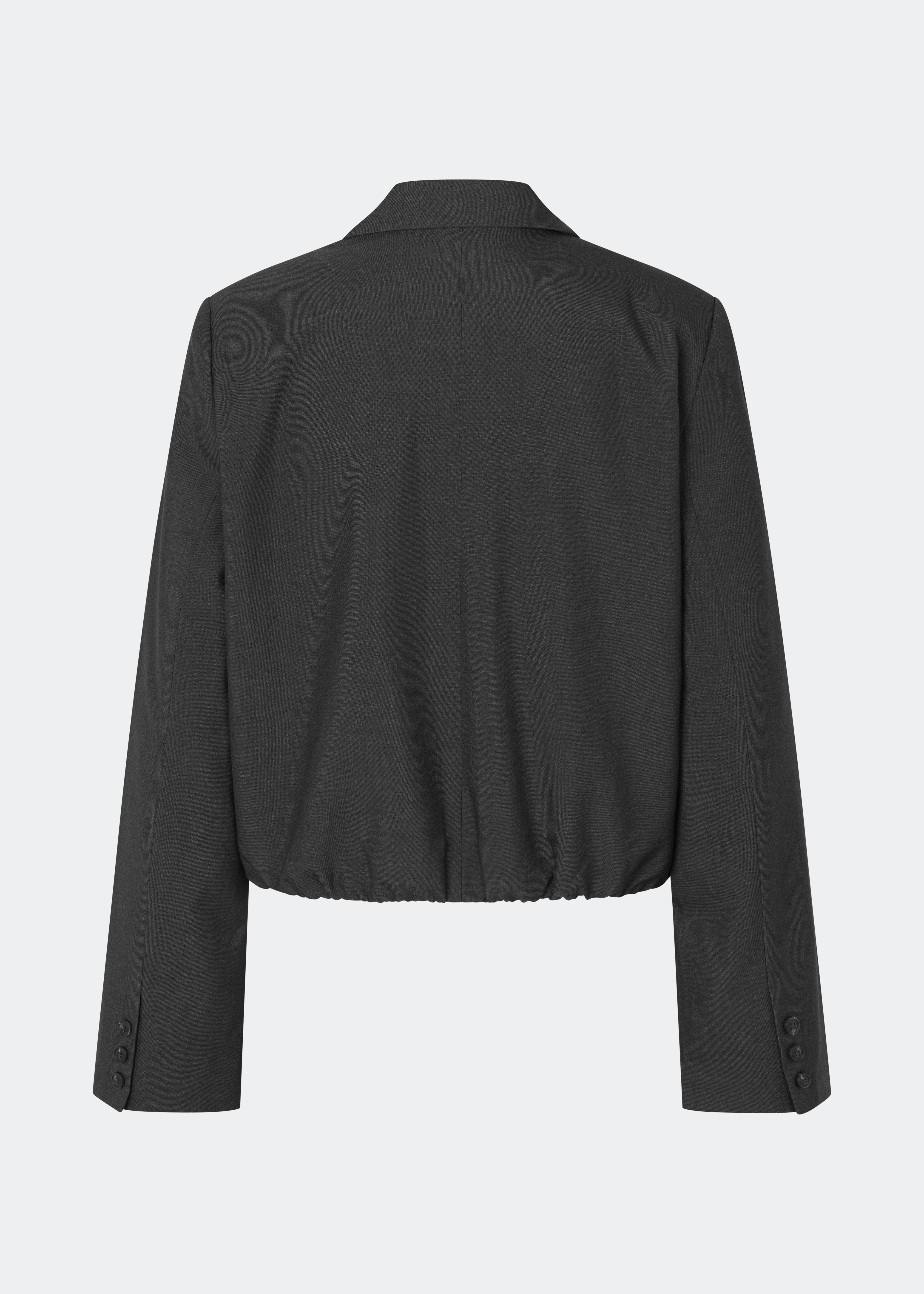 DeanneMD Blazer er en kort blazer med en afslappet, moderne silhuet. Blazeren har klassisk revers, lange ærmer, to knapper foran og elastisk kant forneden, der giver den skræddersyede style et mere casual udtryk. Style den med matchende bukser for et komplet suit-look eller med jeans for en mere afslappet styling. Modellen er 175 cm høj og bruger størrelse S/36.