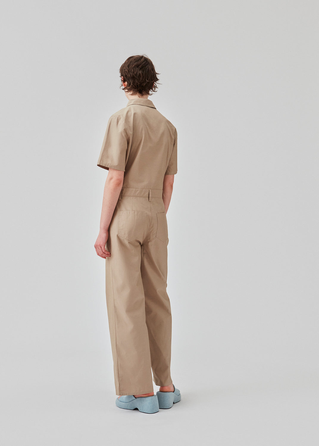 Jumpsuit i sprød bomuldskvalitet med lange, brede ben. DedeMD jumpsuit har korte ærmer, krave, og lynlås foran. Bæltestropper i taljen. Modellen er 177 cm og har en størrelse S/36 på.