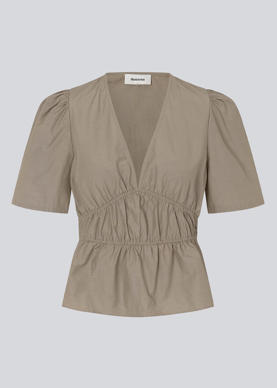 Top i beige i bomuldsblanding med korte ærmer med let puf og dyb v-udskæring i halsen. DeenMD top har flatterende rynkedetaljer under brystet og i taljen. Modellen er 177 cm og har en størrelse S/36 på.