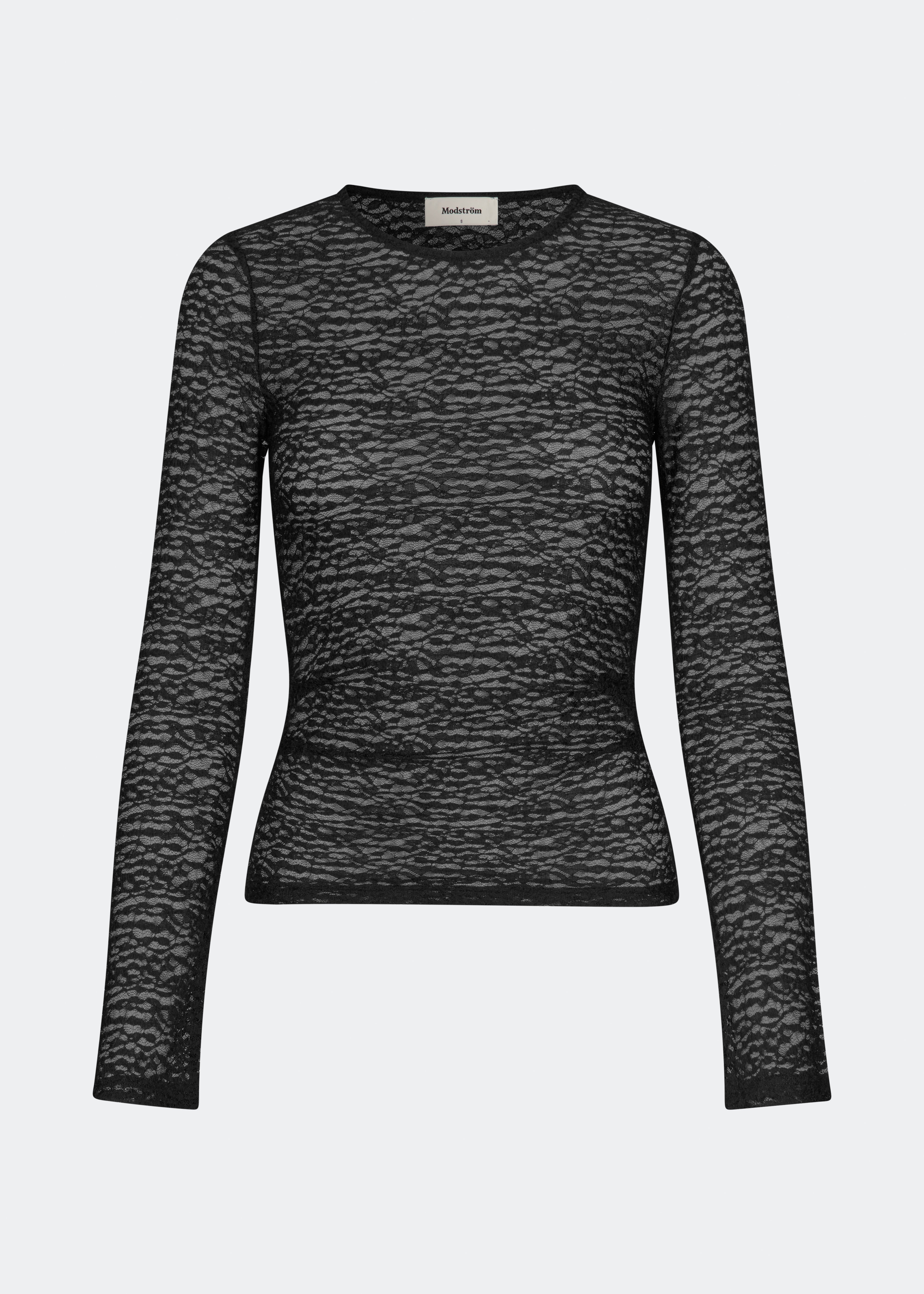Dianamd Top er en tætsiddende blondetop med lange ærmer og et transparent udtryk, der tilfører garderoben et feminint og moderne touch. Den enkle silhuet gør den nem at style alene eller som et lag under blazere, strik eller kjoler, hvor blondedetaljerne får lov at træde frem. Perfekt til både hverdagslooks og særlige anledninger. Modellen er 175 cm høj og bruger størrelse S/36.
