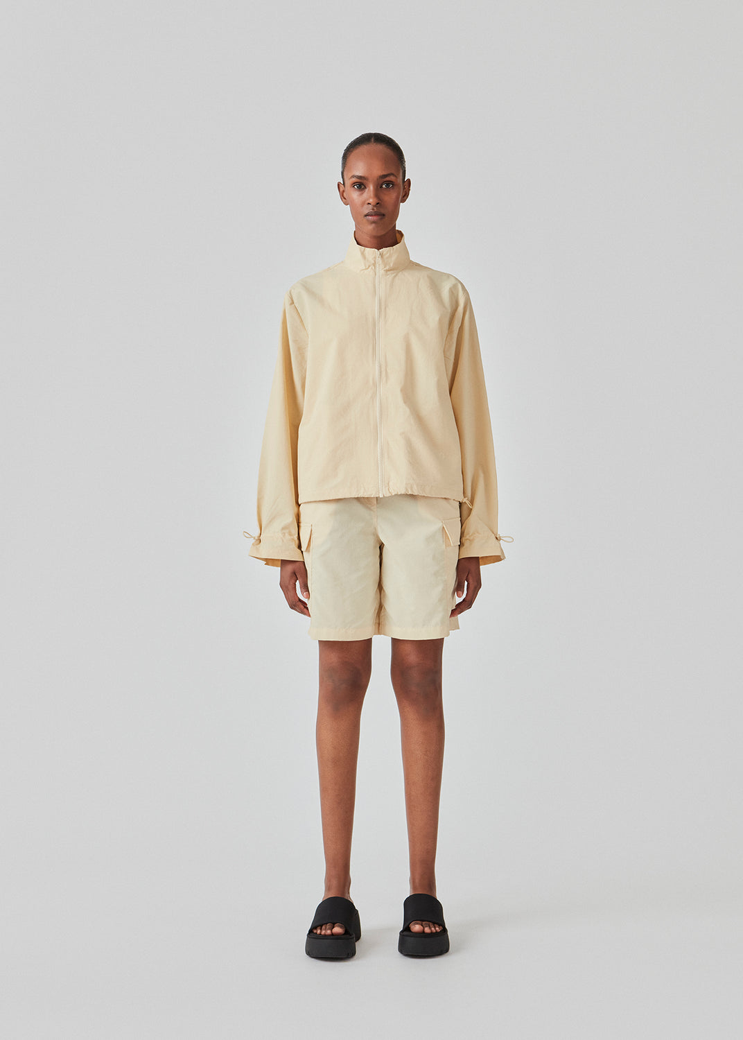 Cargo shorts i farven Pale Sun i nylon med brede ben. DilaraMD shorts har beklædt elastik i taljen og to store påsatte lommer på siden. Modellen er 177 cm og har en størrelse S/36 på.